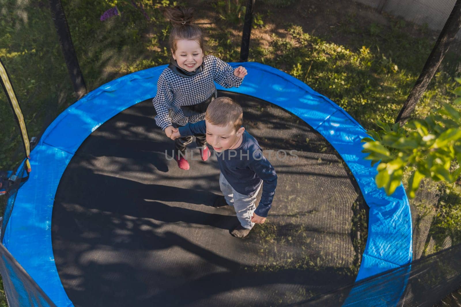 children jumping on a trampoline top view