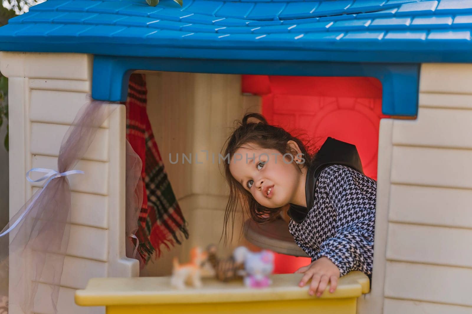 girl playing in her little house by zokov