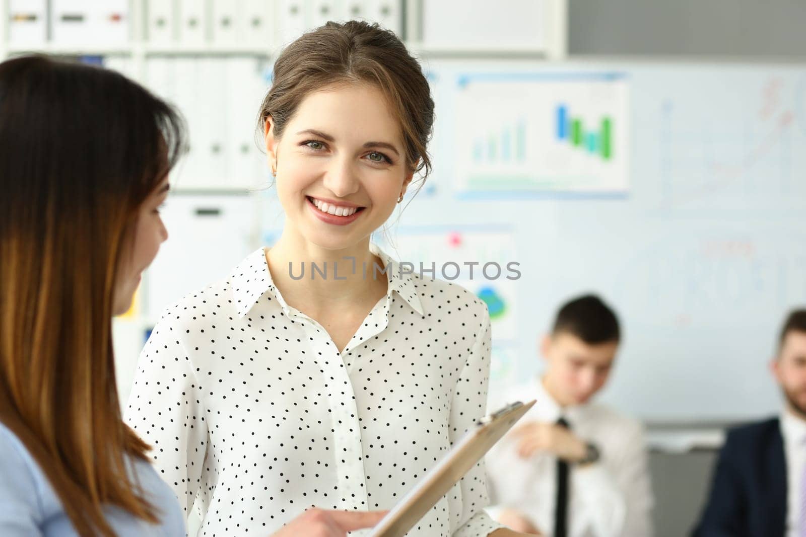 Businesswoman study documents in office. Discuss analytics graph report in team