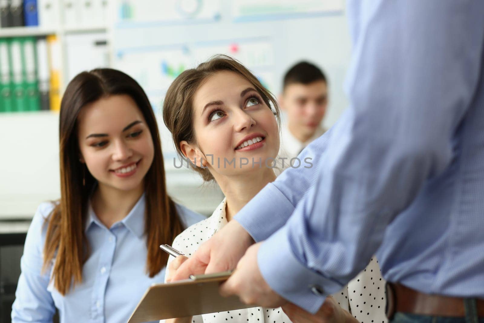 Boss or coach mentor coach showing young female trainee document on training. by kuprevich