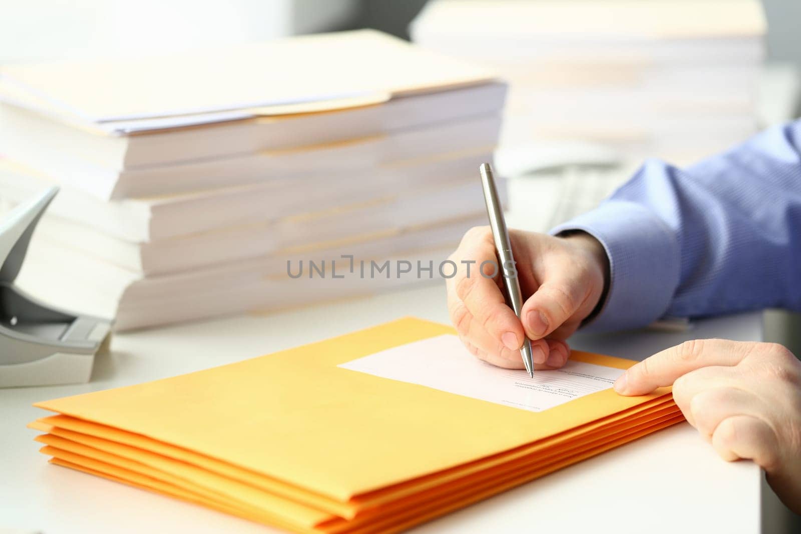 Businessman is preparing parcel for delivery at table in office by kuprevich