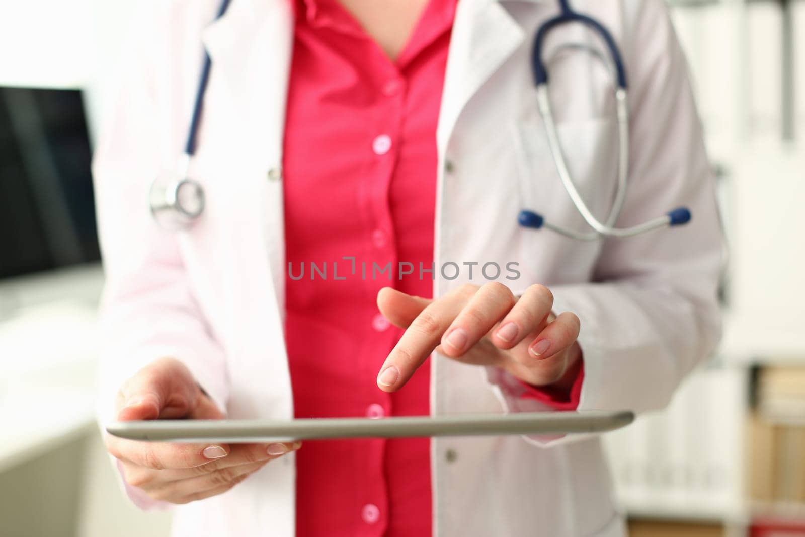 Female doctor is holding modern tablet and using remote telemedicine application. Telehealth concept and remote medical care