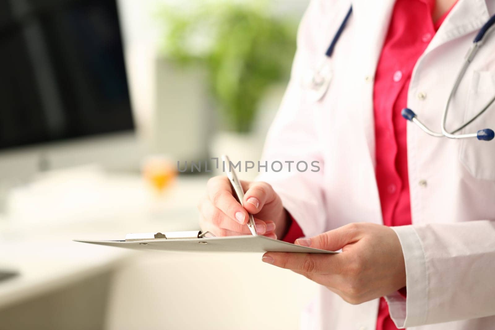 Woman medicine doctor with silver pen writes on a clipboard closeup. Medical calculation and statistics and insurance concept