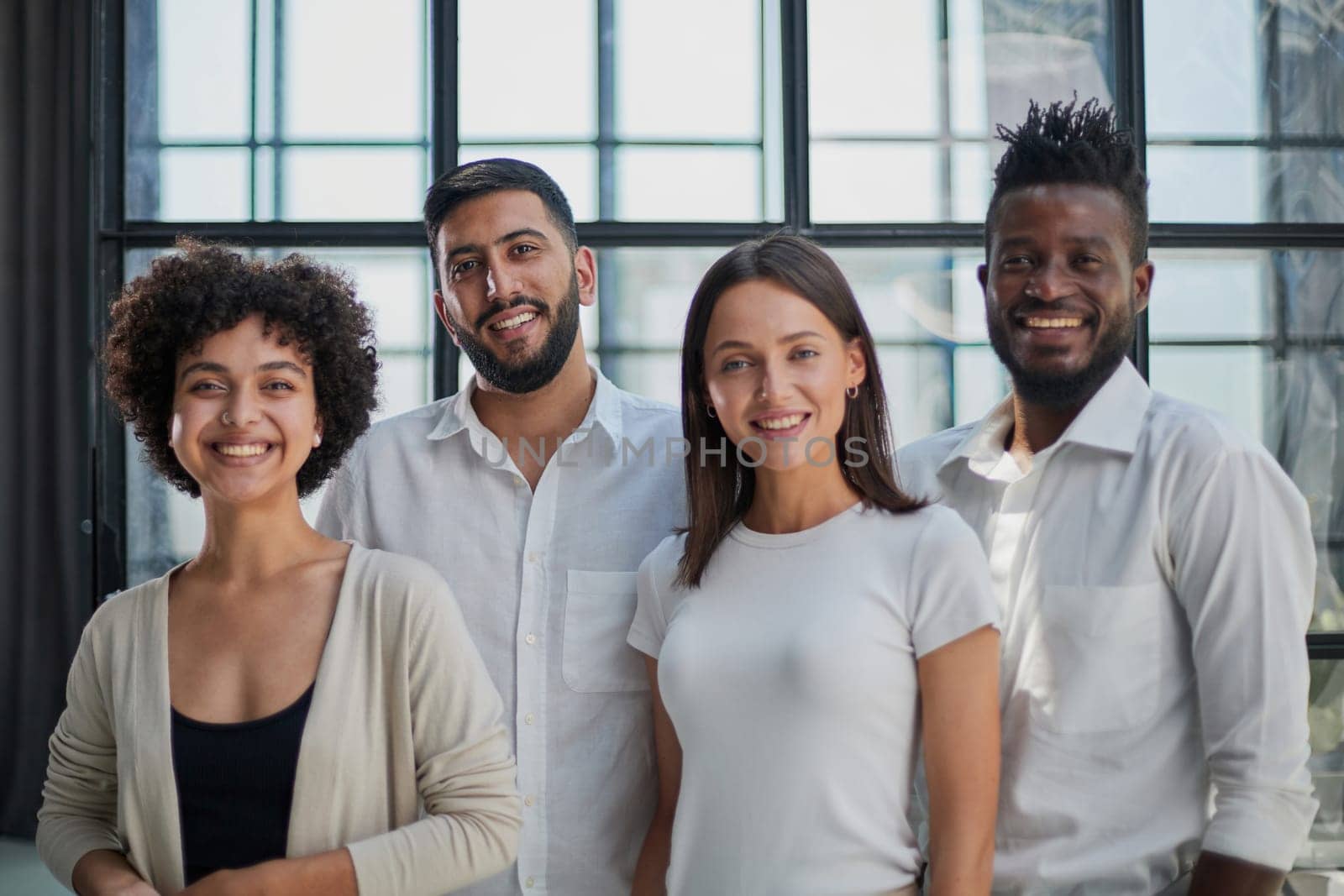 Portrait of successful creative business team looking at camera and smiling. Diverse business people standing together at startup.