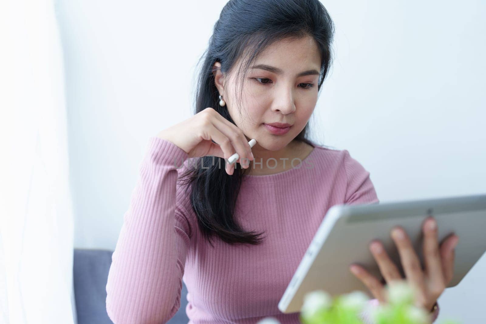 Portrait of a beautiful Asian teenage girl using a tablet computer.