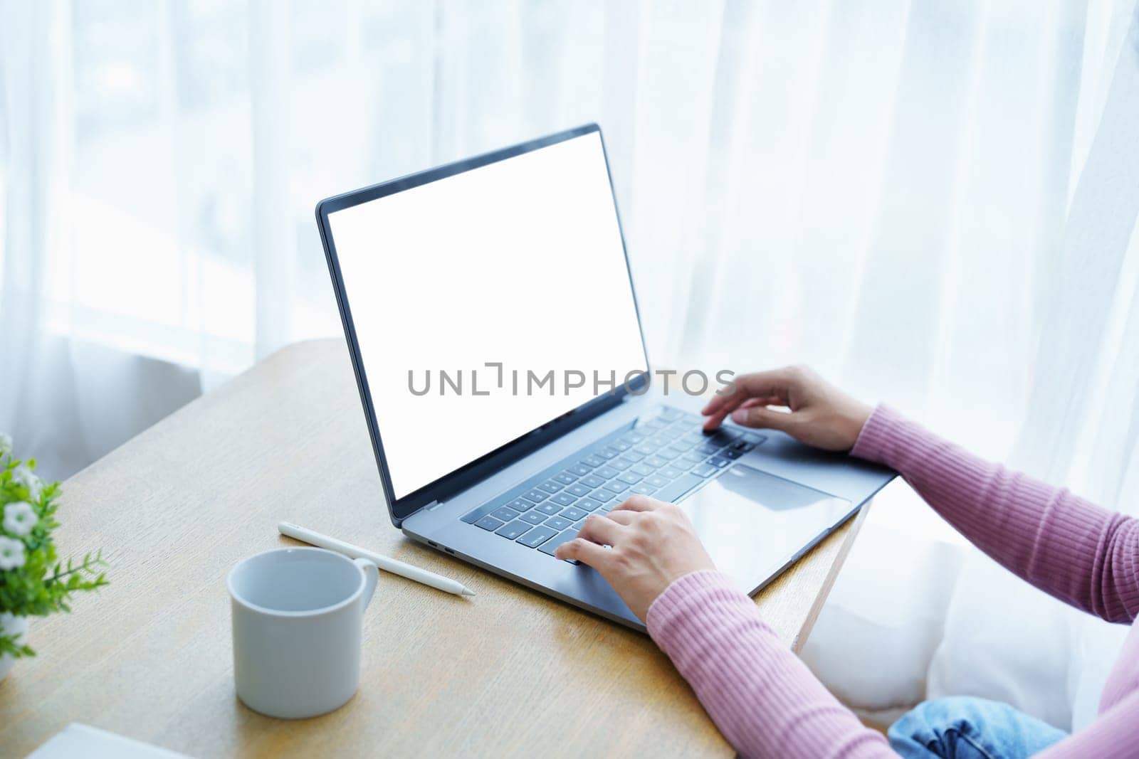 A business woman using blank white screen laptop computer with on her desk.