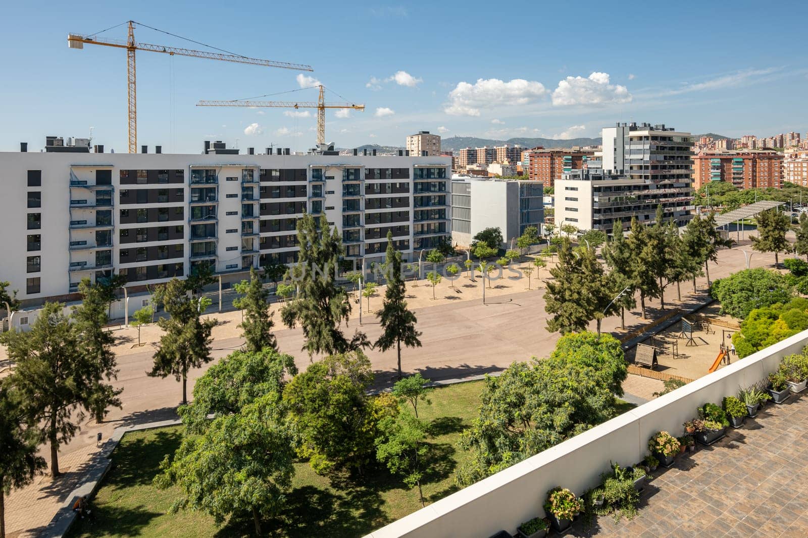 New houses are being built in Gorg, Barcelona in Spain with construction cranes on blue sky on a sunny warm summer day. Concept of new luxury comfortable areas in Europe by apavlin