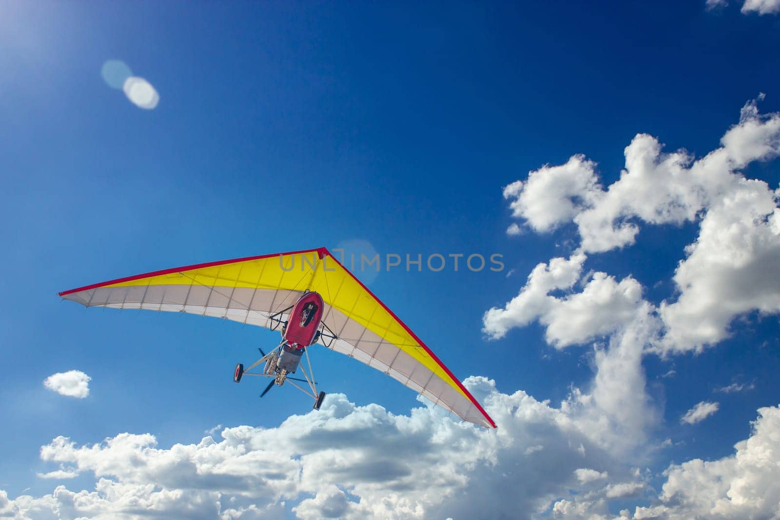 Motorized steerable paraglider flies in the sky, view from below.
