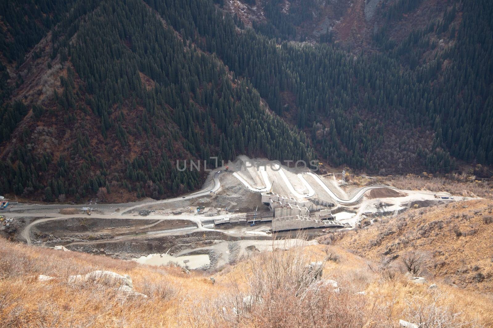 Top view on erection of a mudflow protection dam in the Big Almaty Gorge in the mountains of Almaty. Almaty, Kazakhstan - September 28, 2022