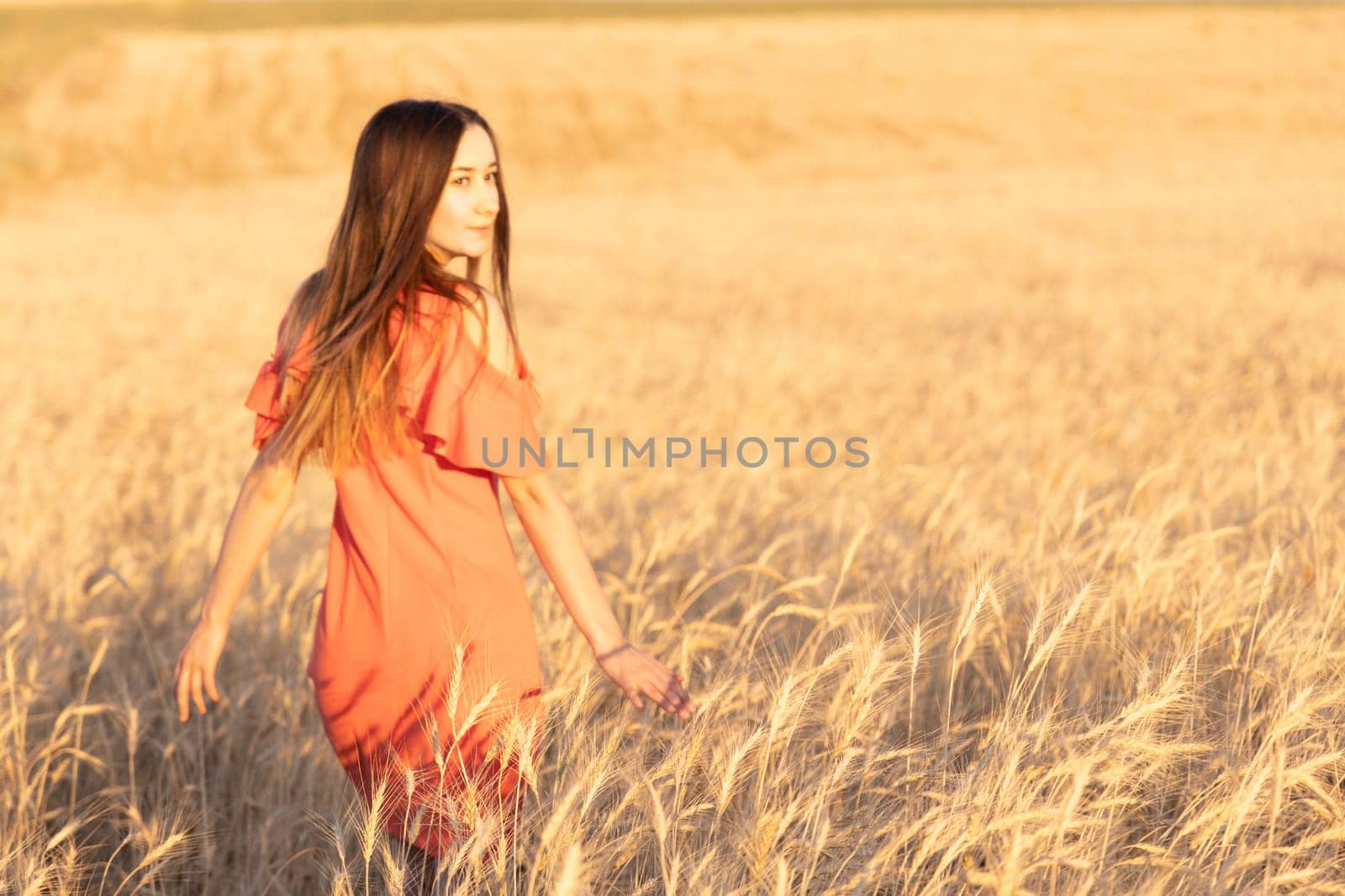 Young woman in the wheat field. Look back. Finding inner balance concept. Copy space.