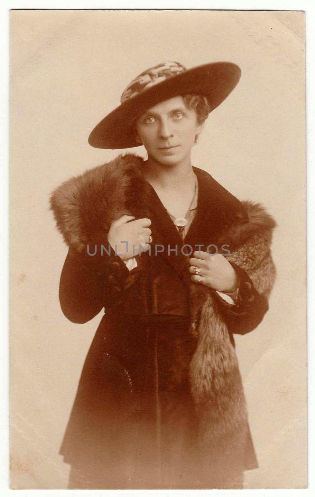 POSEN, POLAND - AUGUST 18, 1920: Vintage photo shows an elegant woman wears fur scarf and wide- brimmed hat.