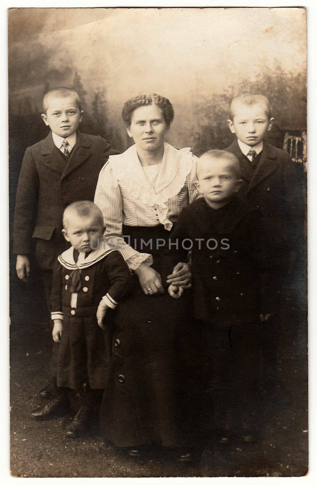 Vintage photo shows mother and her four sons. One of them wears sailor costum. Black white antique photography. by roman_nerud