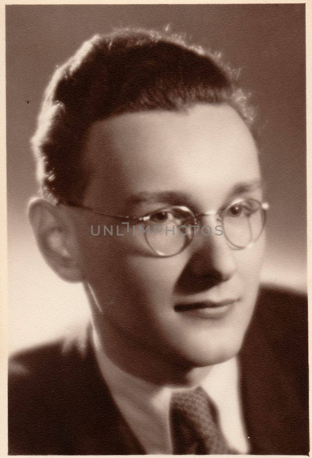 The vintage photo shows young man wears glasses. The photography was taken for A level (GCSE exam) occasion. by roman_nerud