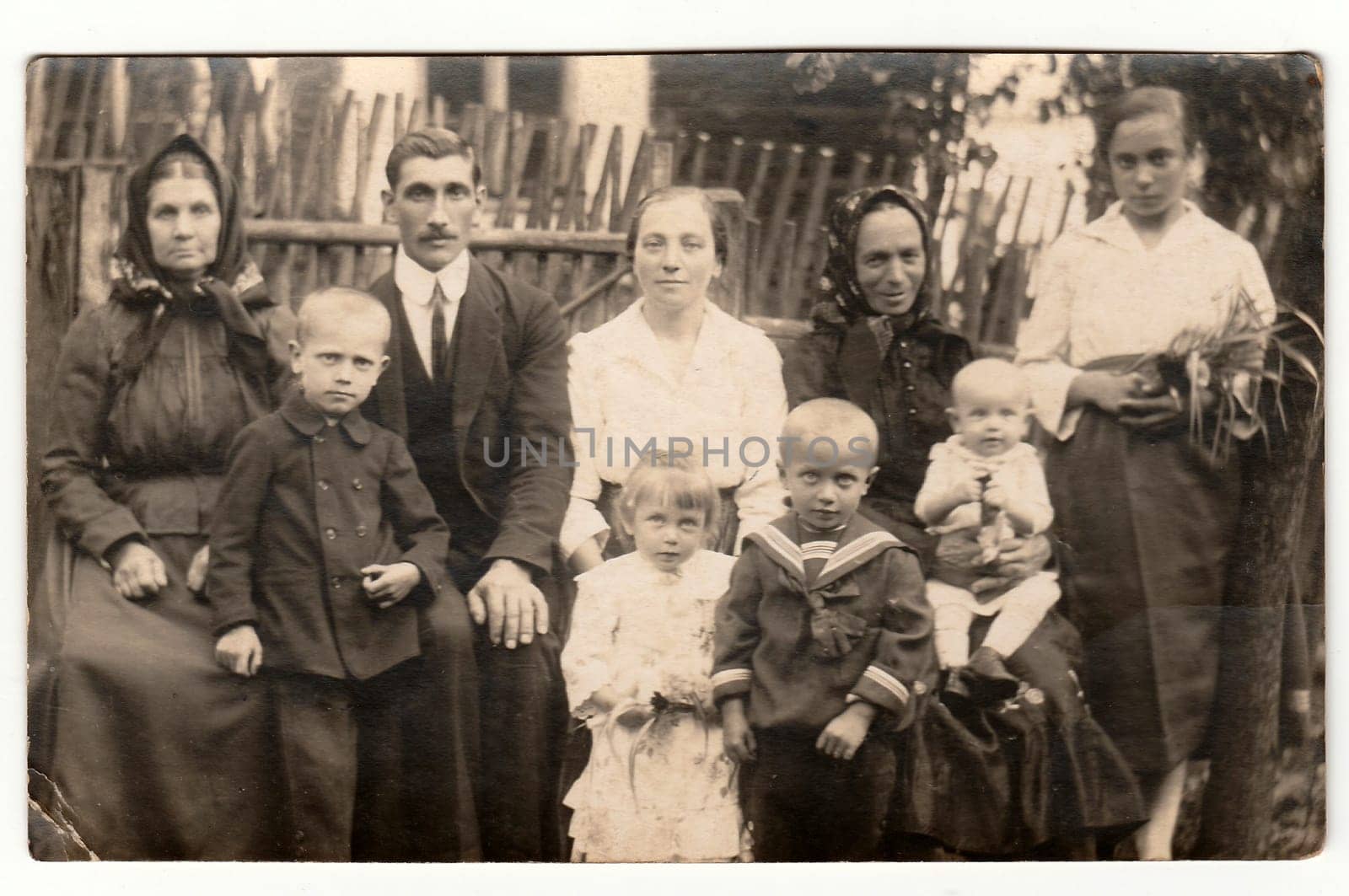 THE CZECHOSLOVAK REPUBLIC - CIRCA 1930s: Vintage photo shows a big rural family in front of wooden fence. Black & white antique photography.