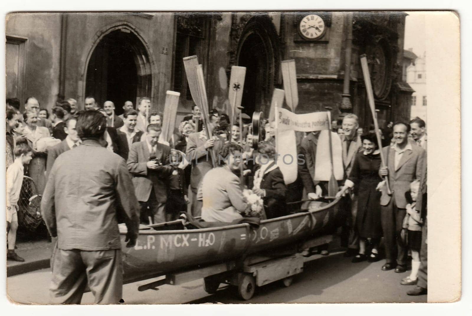 Vintage photo shows people (newlyweds and wedding guests) make fun after wedding ceremony. Newlyweds and friends are fans of paddling (sports), watermanship. by roman_nerud