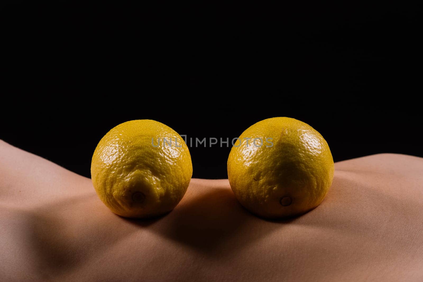 Young woman with cellulite problem and lemon on dark background, closeup by Zelenin