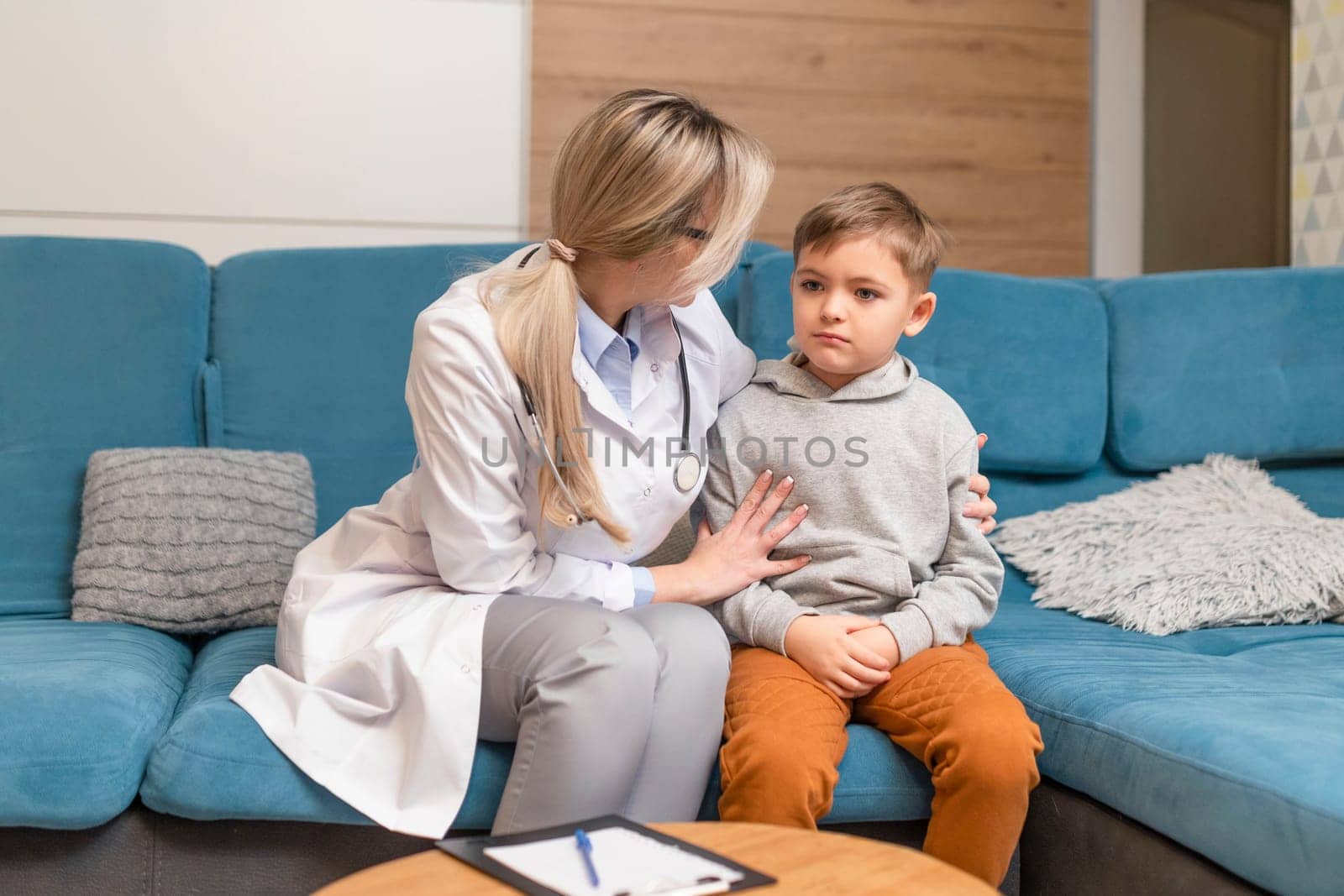 A family doctor examines a little boy at home. Pediatrician girl treats a child.