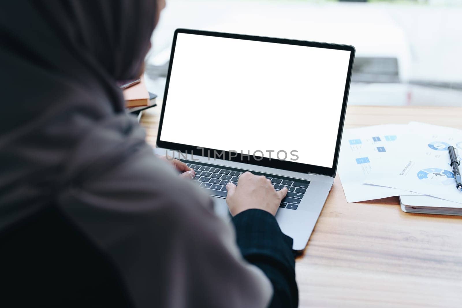 A beautiful Muslim woman uses a white computer screen ready to put text and illustrations on empty spaces.