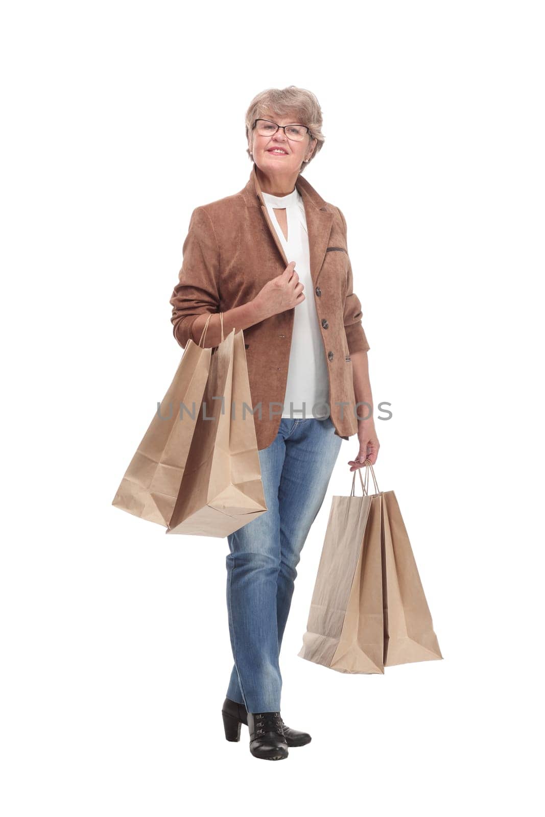 Full length portrait of a Senior woman walking with shopping bags and smilimg