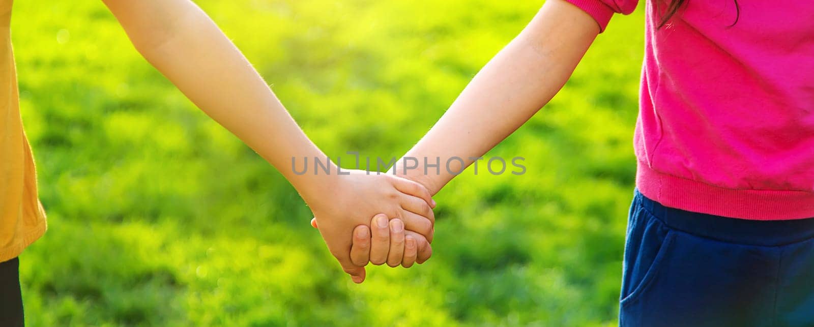 Children walk together holding hands. Selective focus. by yanadjana