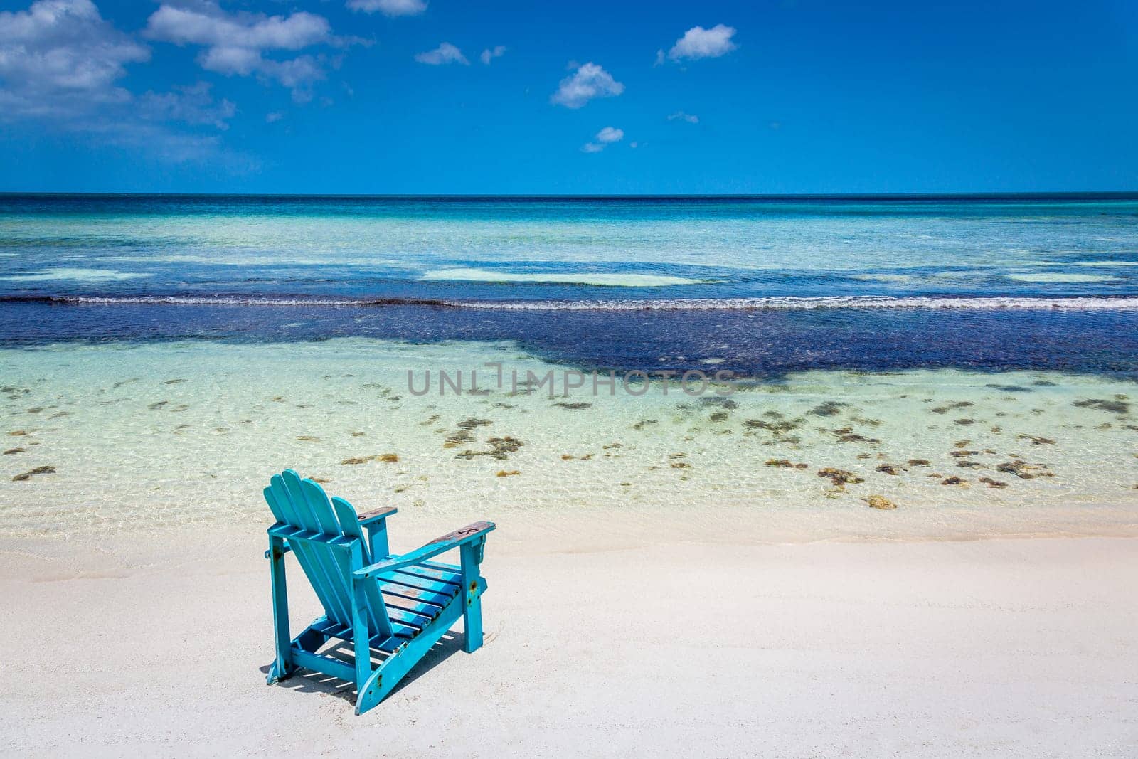 Adirondack Chair and secluded eagle beach on Aruba island, Caribbean sea by positivetravelart