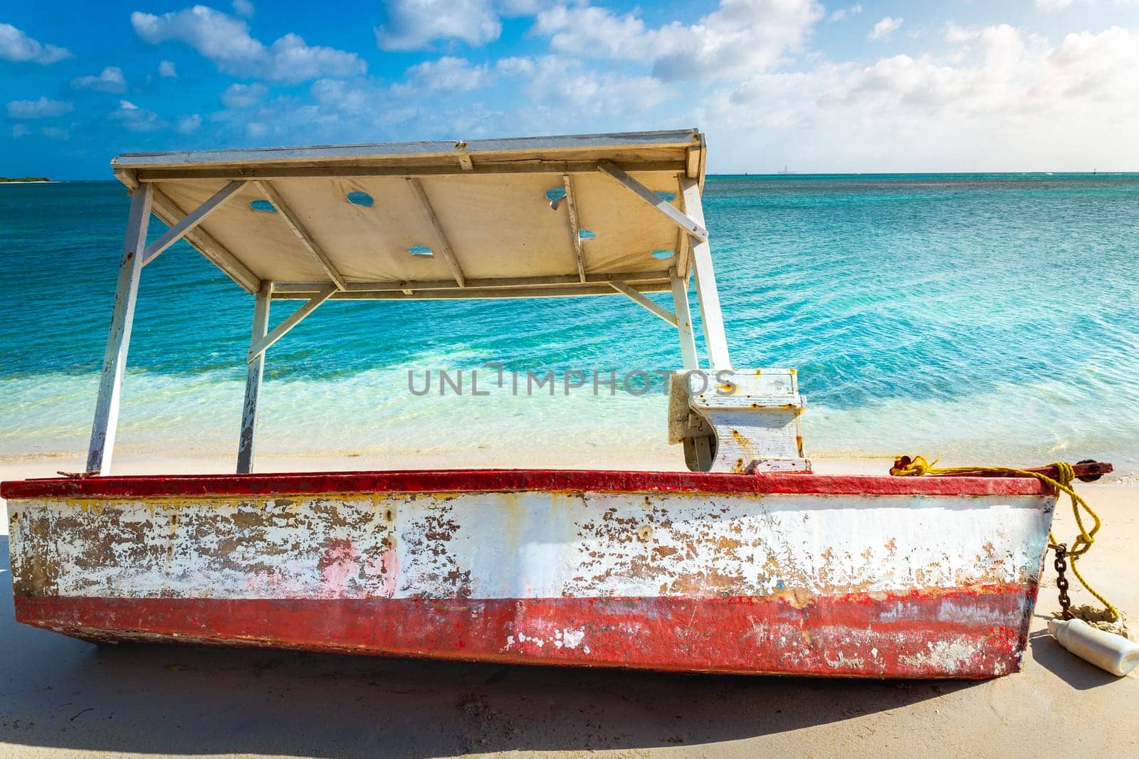 Trawler fishing boat on secluded beach in Aruba island, Caribbean sea by positivetravelart