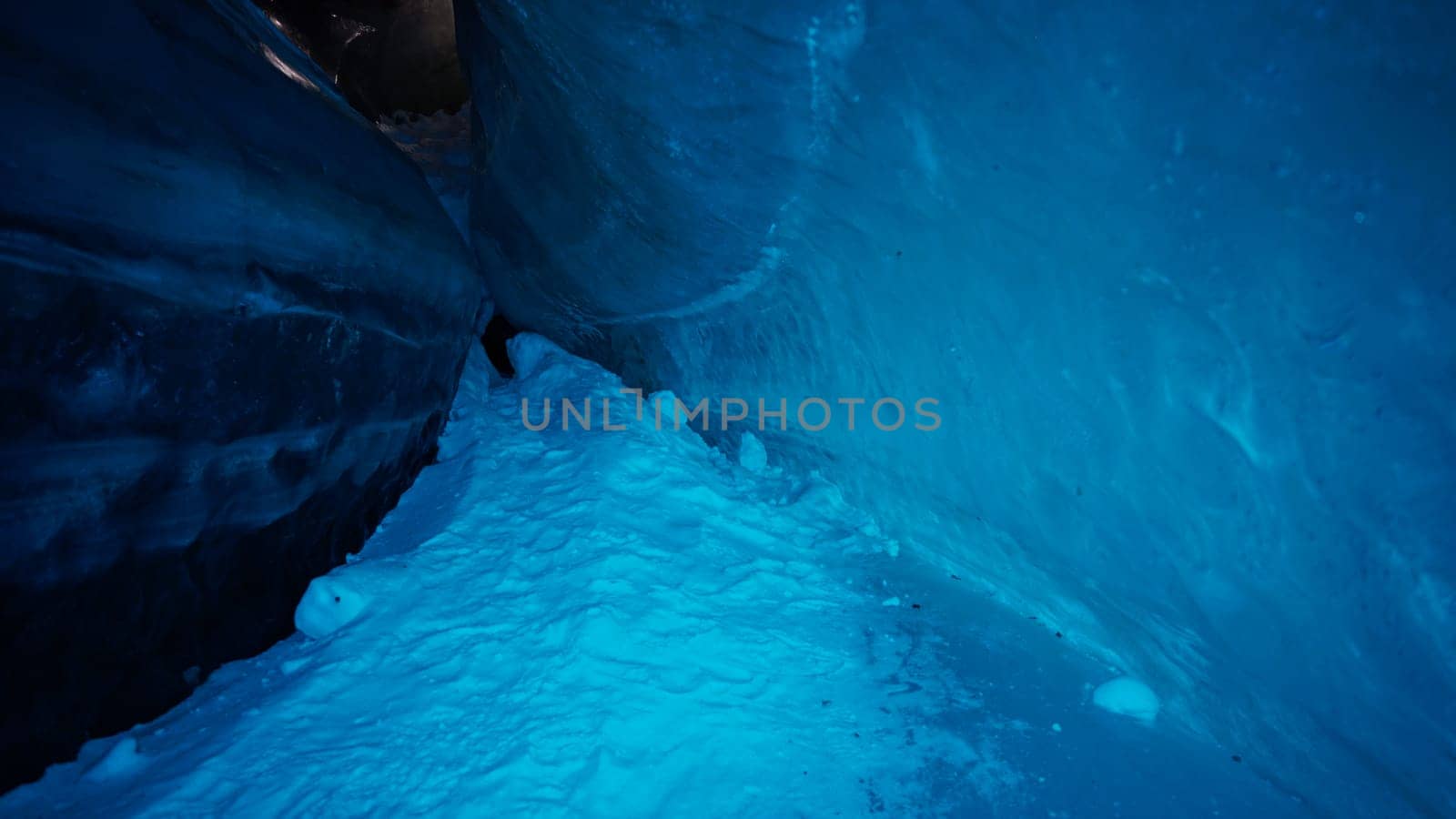 A huge corridor inside an ice cave in mountains by Passcal