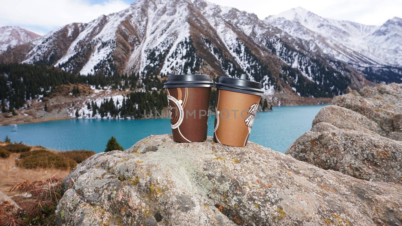 Paper cups on the background of a mountain lake by Passcal