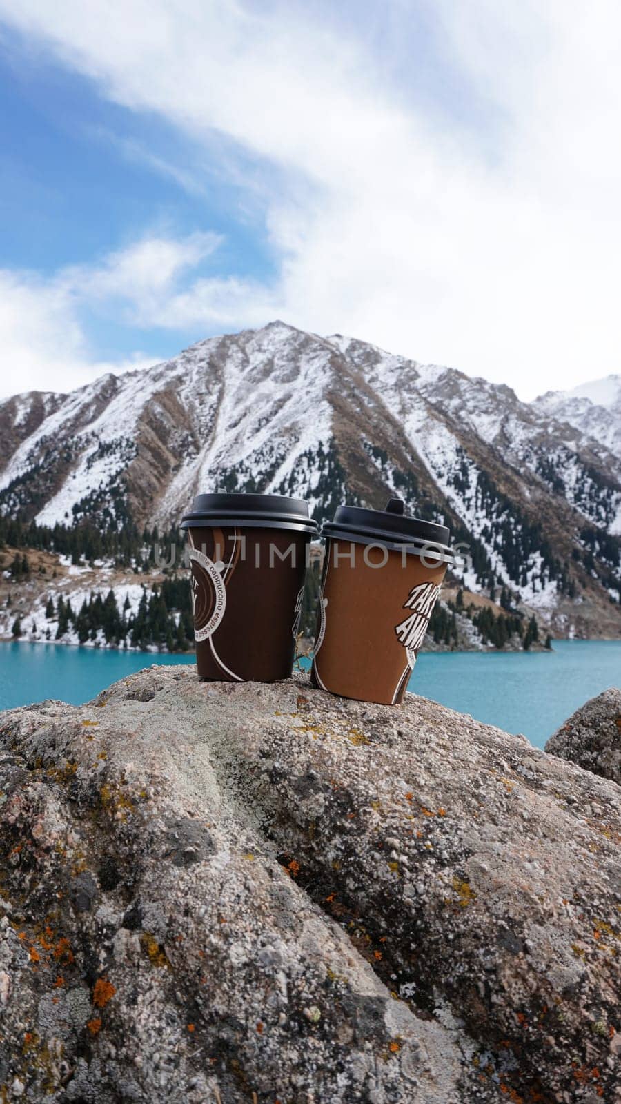 Paper cups on the background of a mountain lake by Passcal