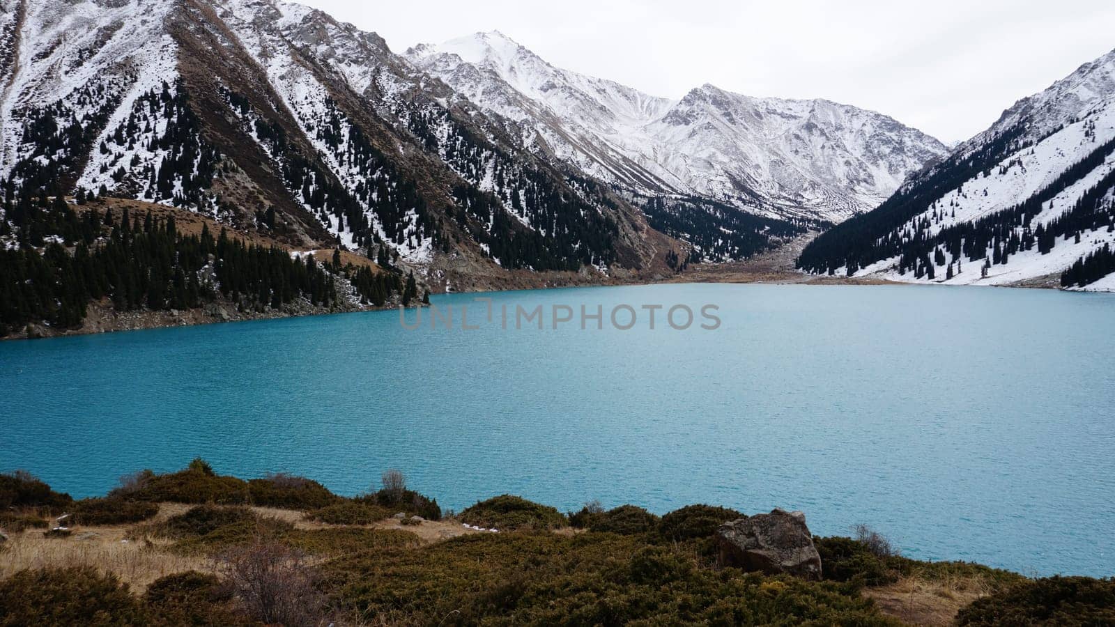 A mountain lake with blue water in winter by Passcal