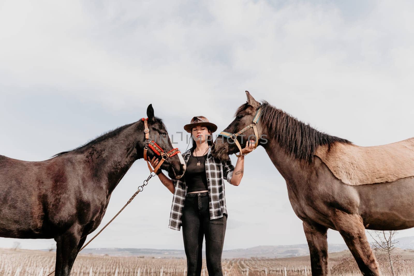 Cute happy young woman with horse. Rider female drives her horse in nature on evening sunset light background. Concept of outdoor riding, sports and recreation.