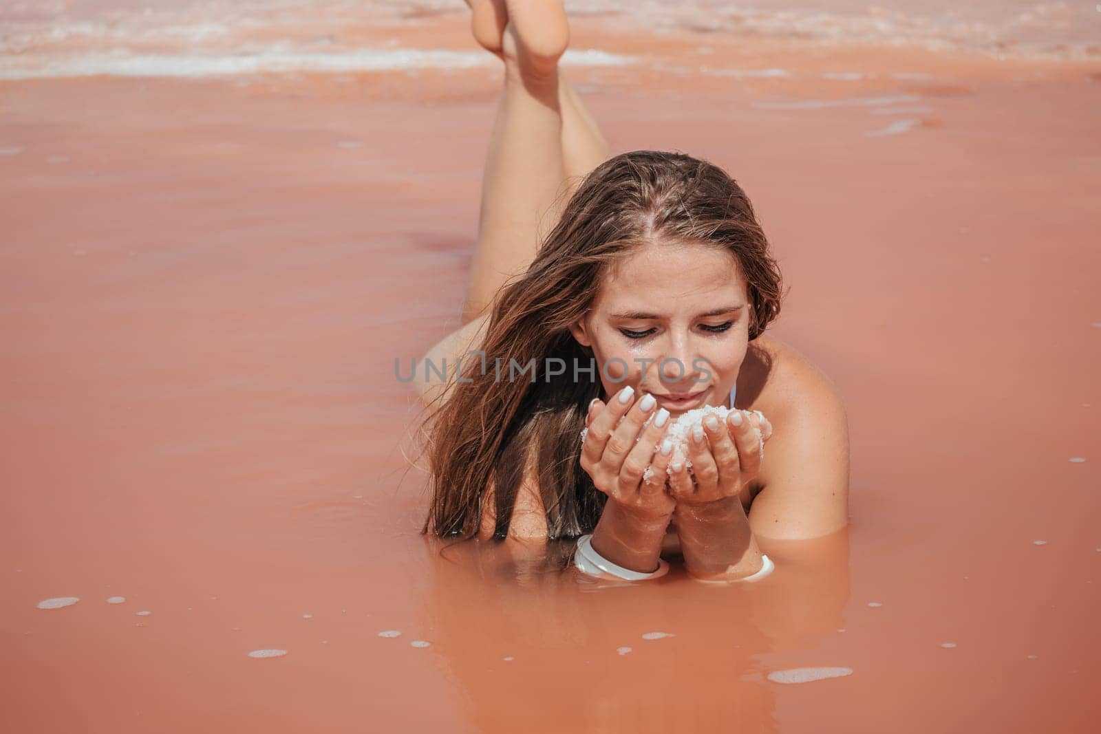 Salt mining. Salty pink lake with crystals of salt. Extremely salty pink lake, colored by microalgae with crystalline salt depositions