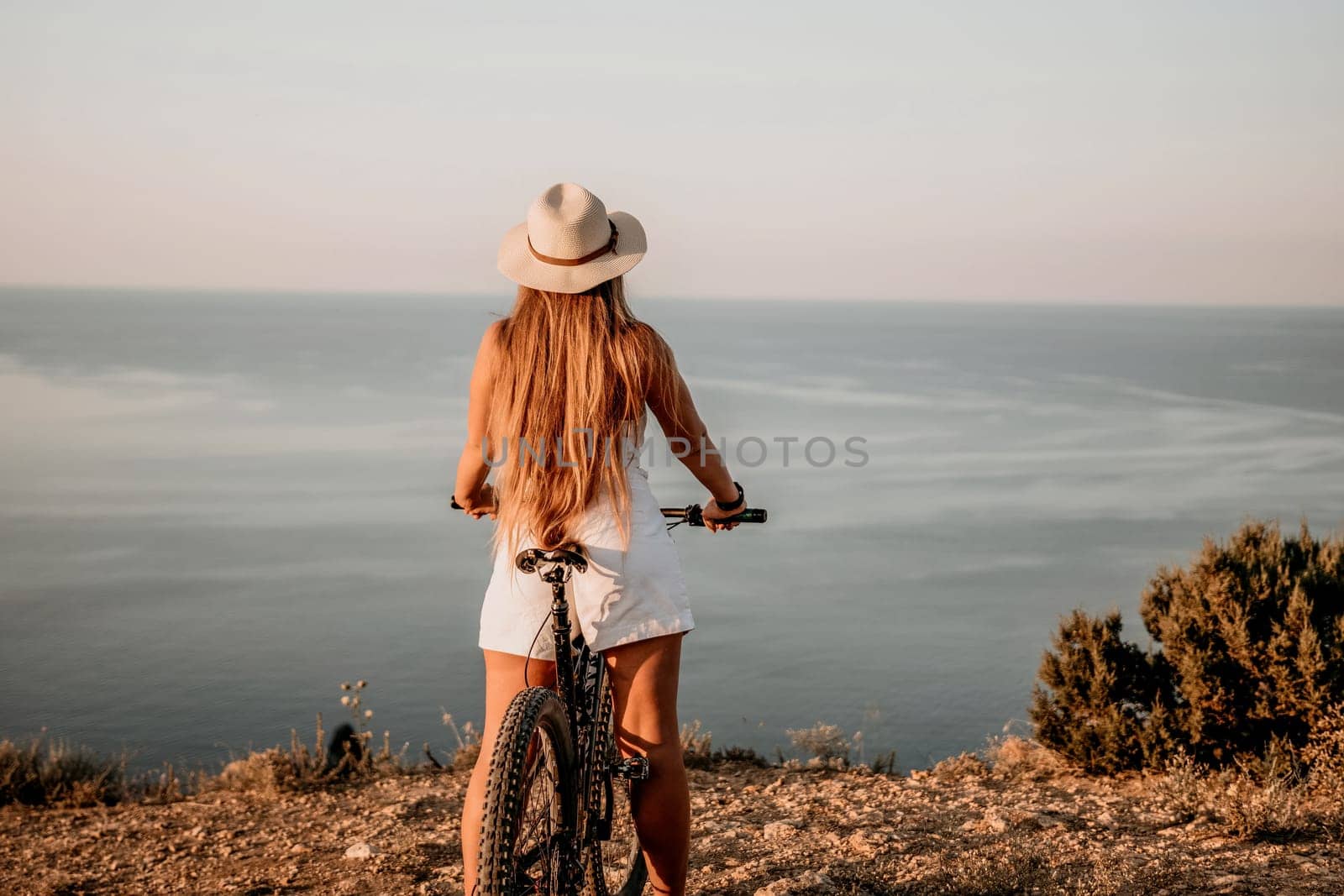 Woman travel sea. Young Happy woman in a long red dress posing on a beach near the sea on background of volcanic rocks, like in Iceland, sharing travel adventure journey