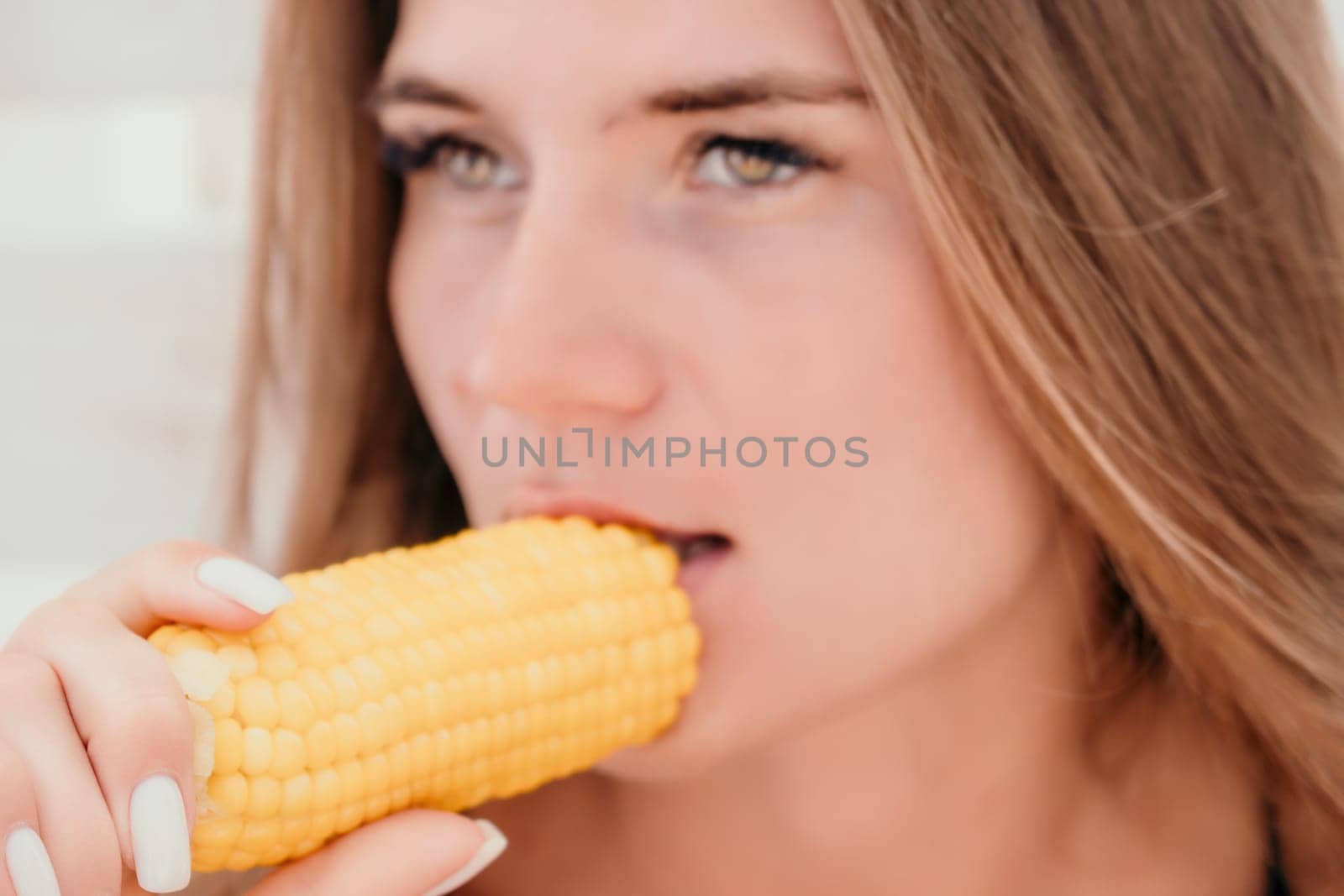 Healthy vegetarian hipster woman in summer outfit eat grilled corn and look to camera. Sexy lady on sea beach sunset or ocean sunrise. Travel, explore, active yoga and meditation lifestyle concept.