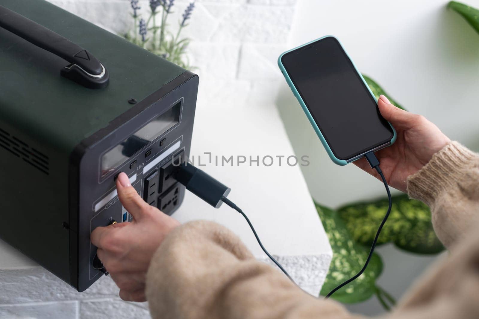 Charging mobile phone battery with wireless charging device in the table. Smartphone charging on a charging pad. Mobile phone near wireless charger Modern lifestyle technology. by Andelov13