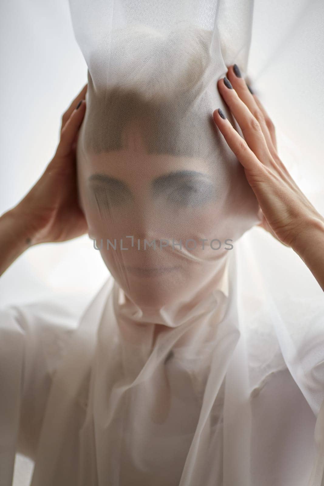 Woman portrait pulling fabric over her face hiding face mask by Demkat