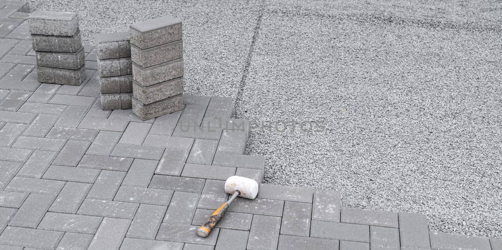 building a sidewalk, laying interlocking pavers.