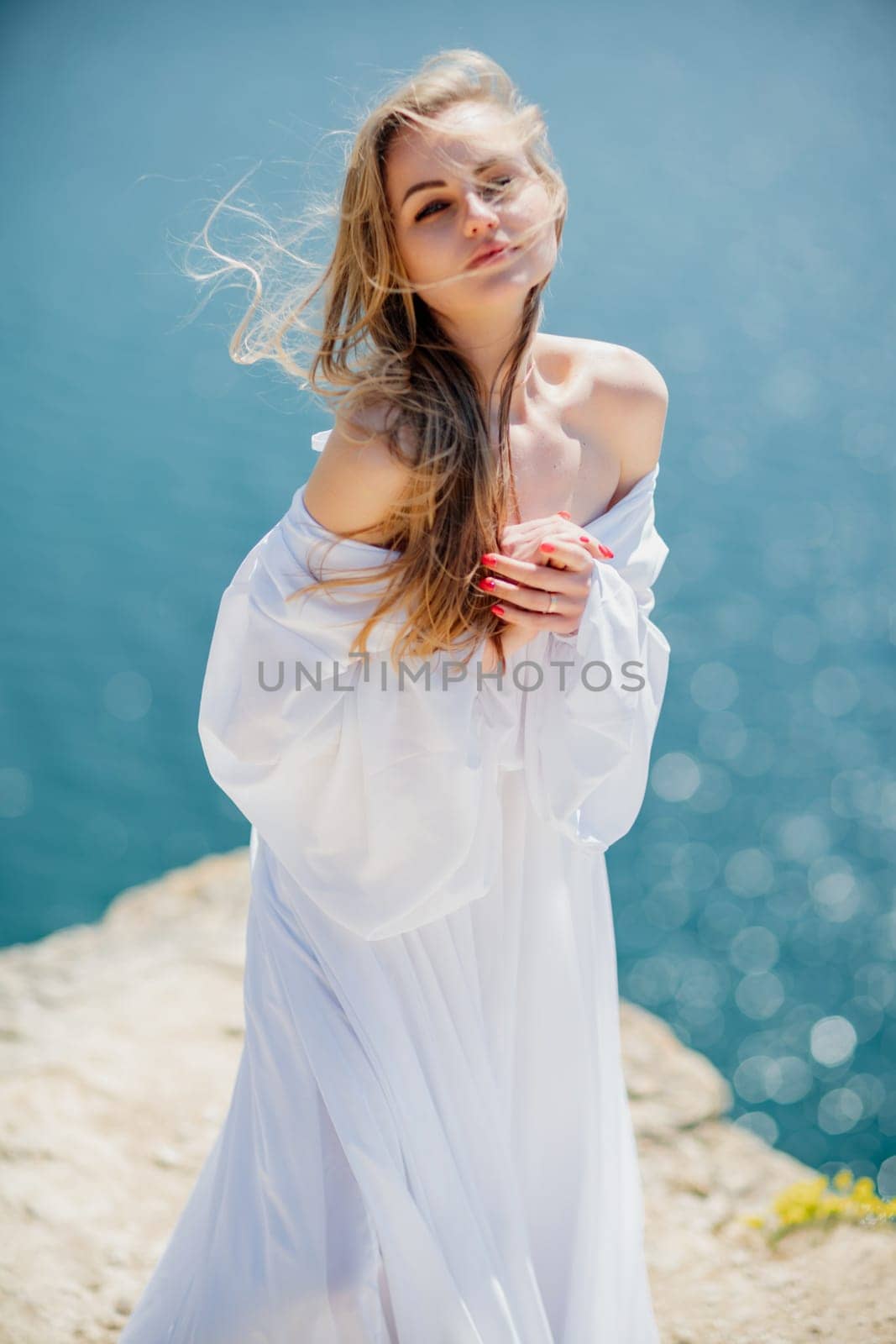 Portrait of a blond woman at the sea, a woman makes photos for memory from a trip to the sea to show to friends. by Matiunina