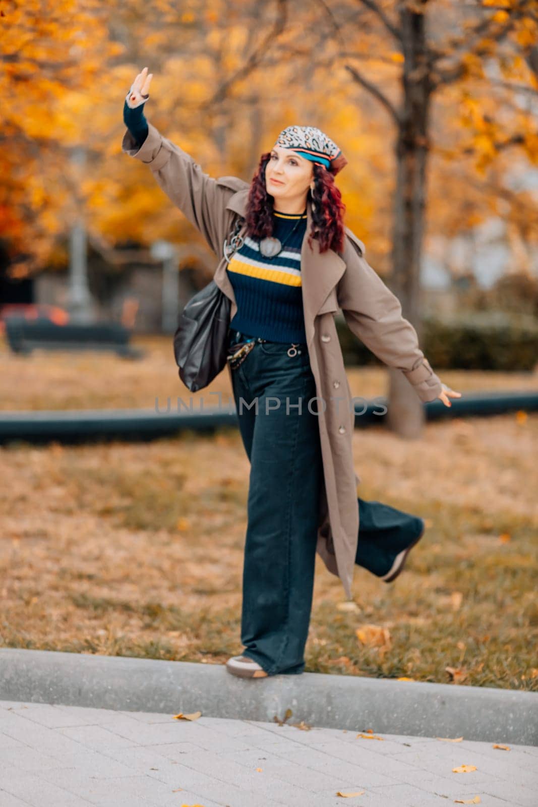 A woman walks outdoors in autumn, enjoys the autumn weather