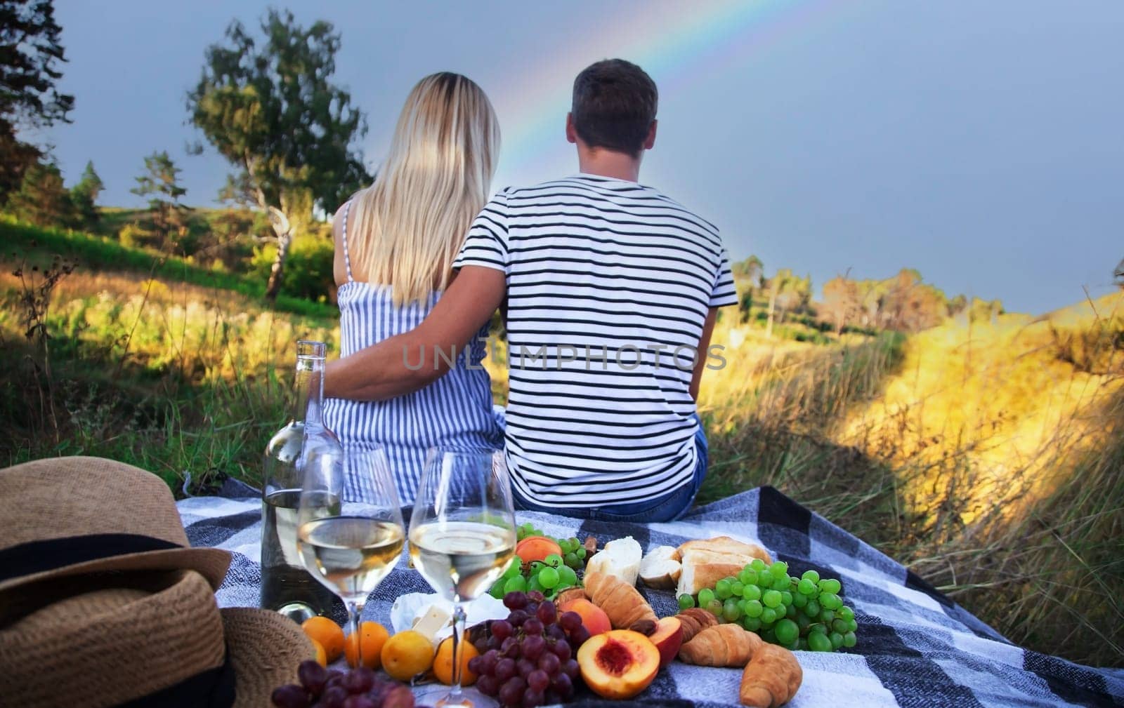 couple in love drinking wine on a picnic. Selective focus by Anuta23