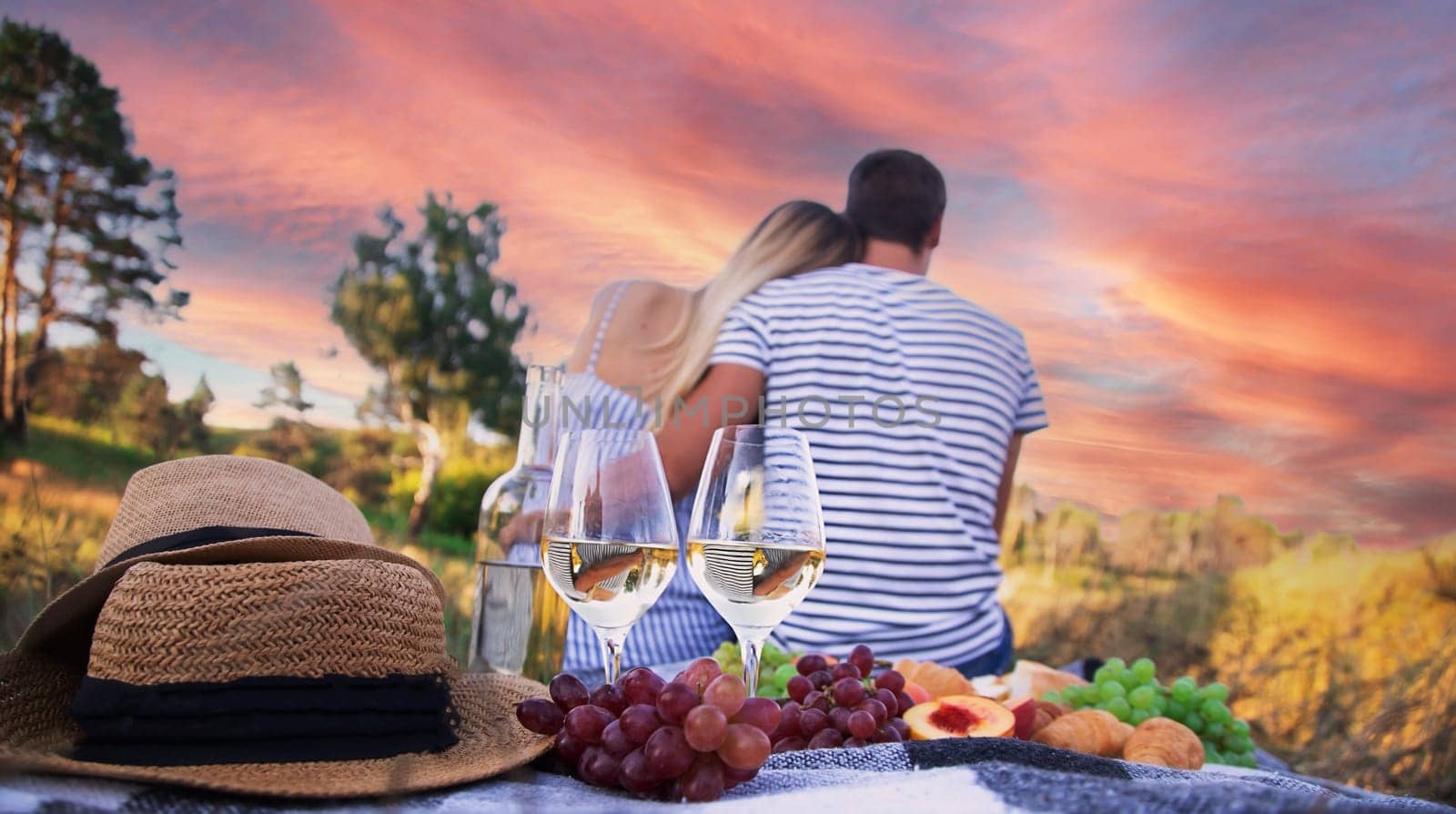 couple in love drinking wine on a picnic. Selective focus by Anuta23