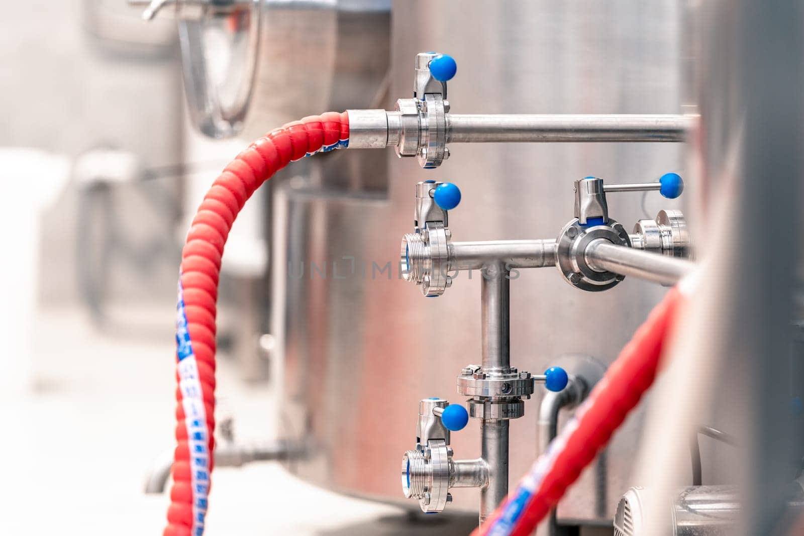 stainless steel boilers and vessels with pipes for brewing beer in a brewery.