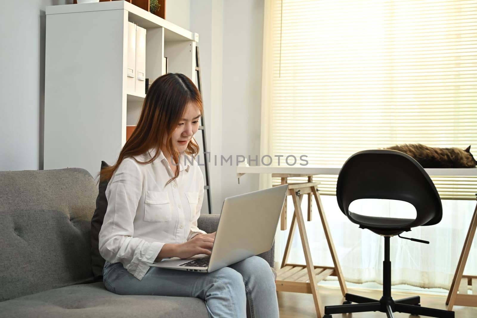 Young asian woman reading news online, checking social media on laptop at home. People, technology and lifestyle concept.