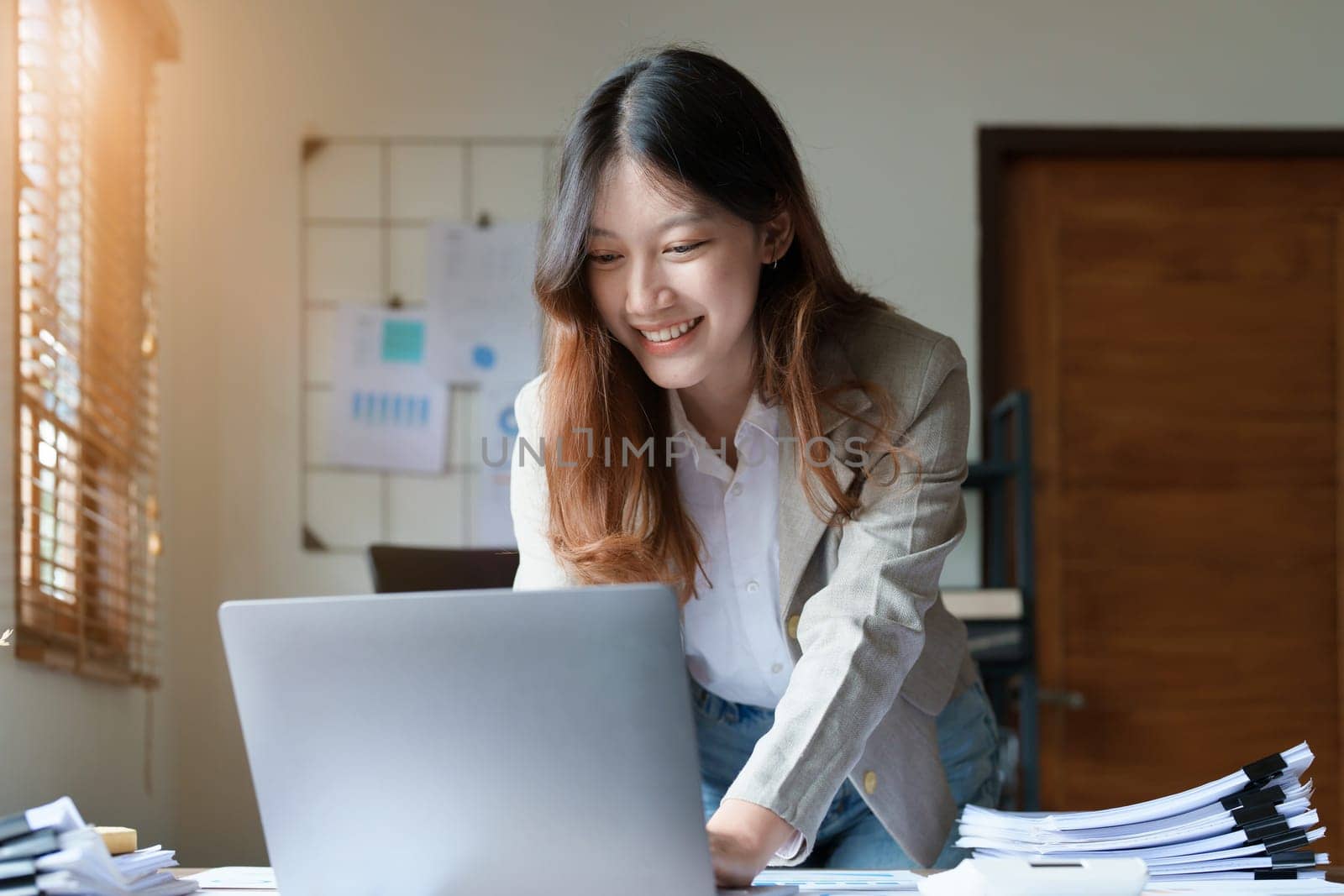financial, Planning, Marketing and Accounting, portrait of Asian employee checking financial statements using documents and computer laptop at work by Manastrong