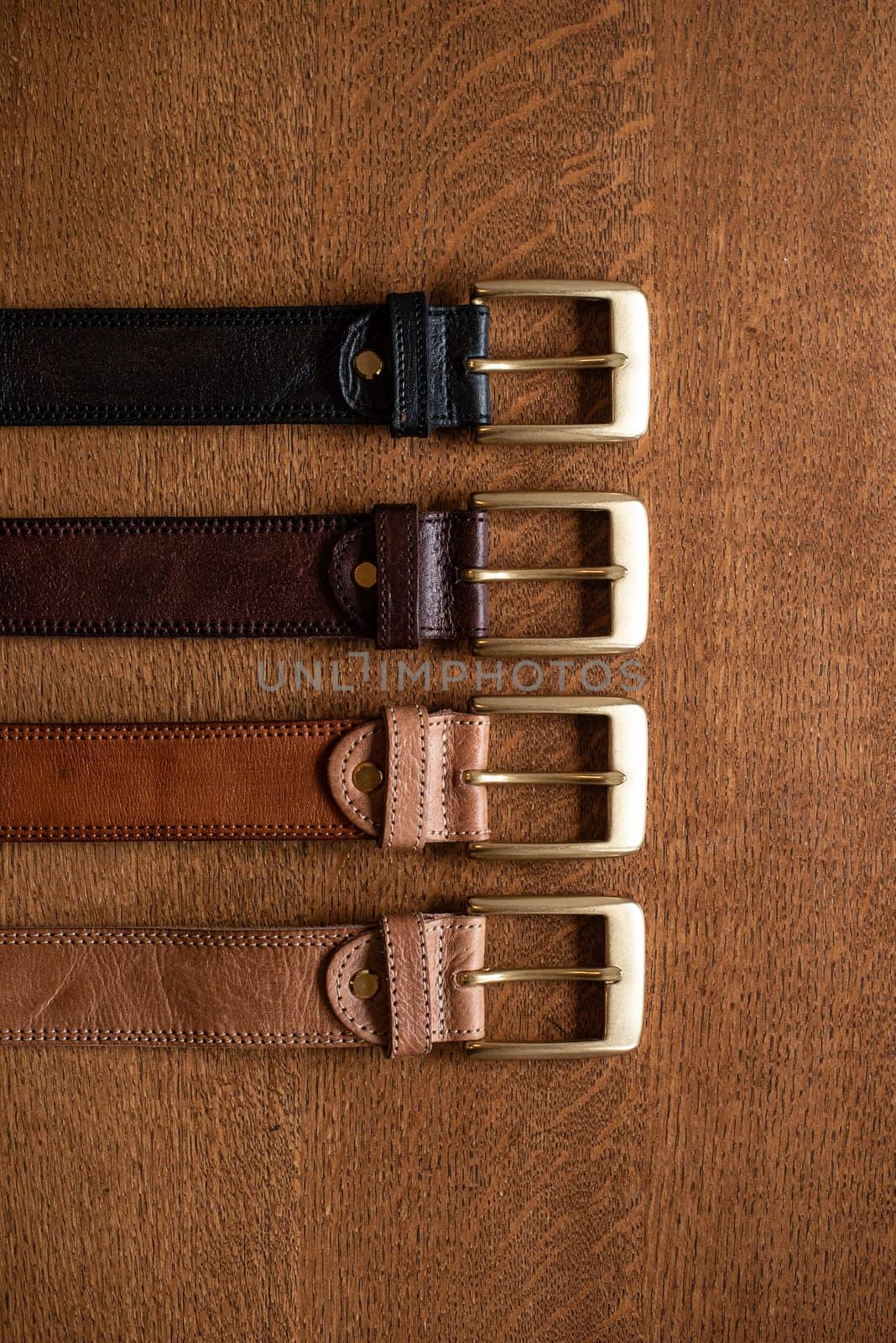 Leather belts set on a wooden table. natural lighting.