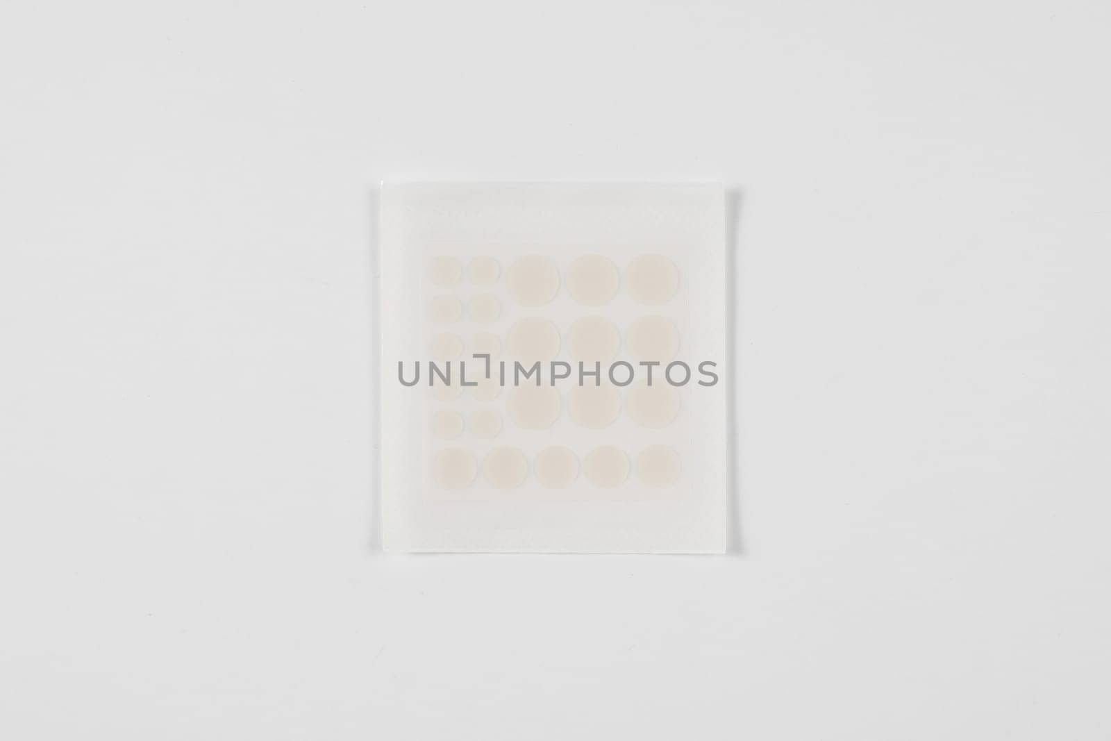 Set of round acne patches on white background. Close-up acne patch facial rejuvenation. Facial cleansing cosmetology. by Rabizo