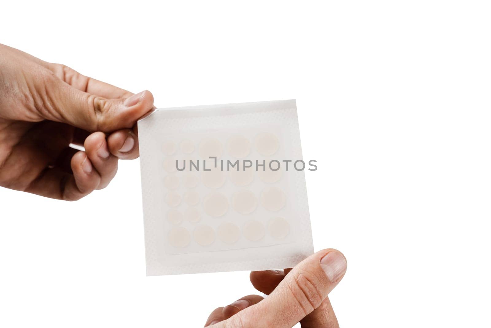 Hands holding set of round acne patches on white background. Close-up acne patch facial rejuvenation. Facial cleansing cosmetology. by Rabizo