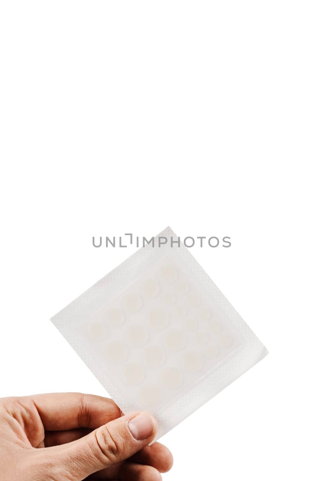 Set of round patches for acne in hand on white background. Top view of acne patch for facial rejuvenation. Facial cleansing cosmetology. by Rabizo