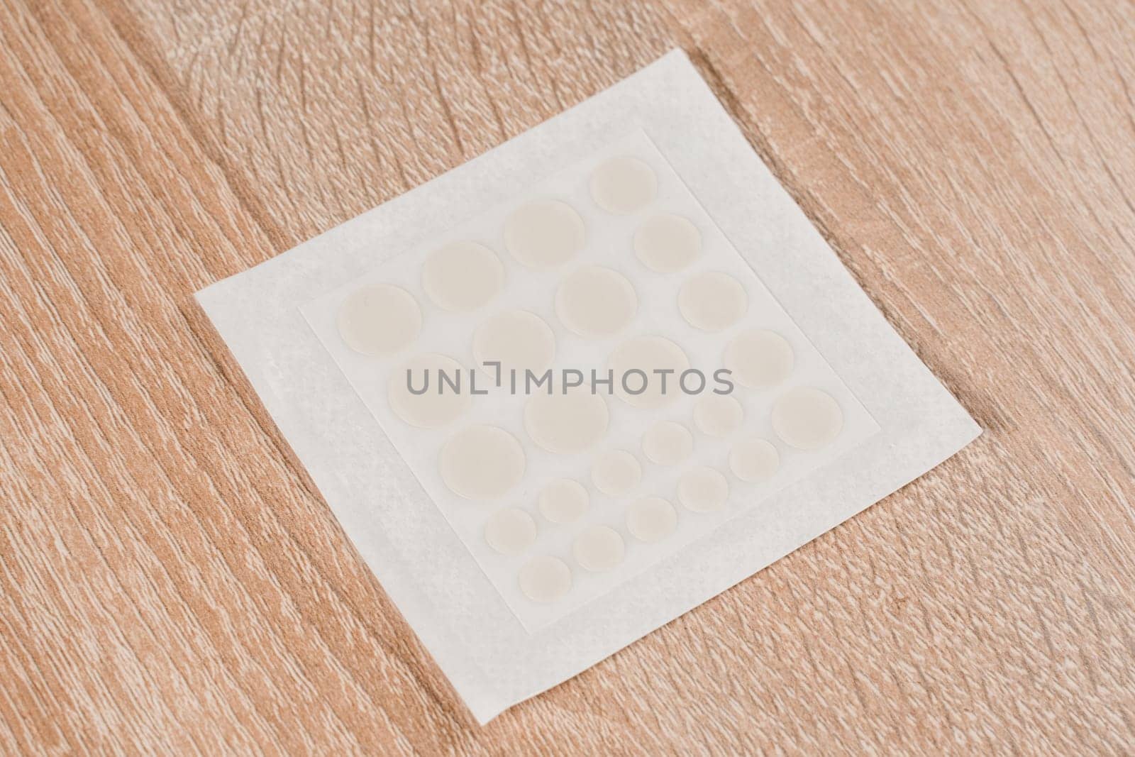 Set of round acne patches on wooden background. Close-up acne patch facial rejuvenation. Facial cleansing cosmetology