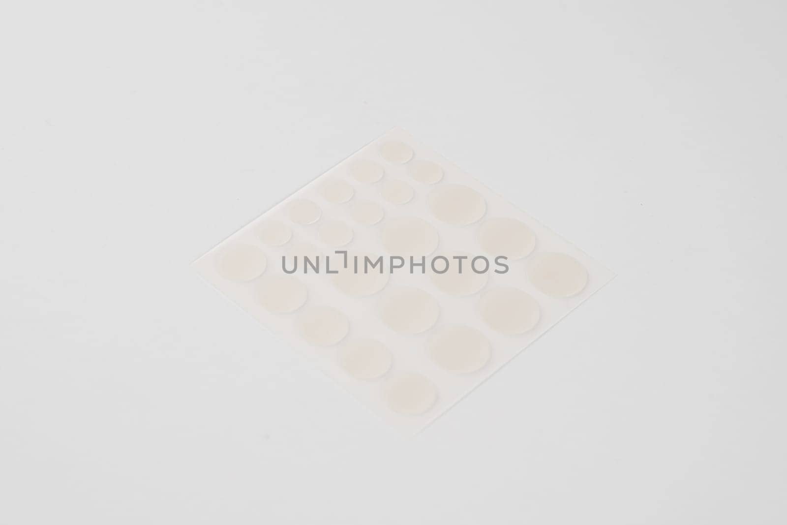 Set of round patches for acne on white background. Acne patches for the treatment of pimple and rosacea close-up. Facial rejuvenation cleansing cosmetology. by Rabizo
